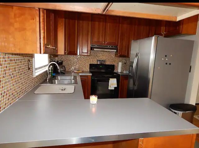 a kitchen with stainless steel appliances a refrigerator a sink a stove and cabinets