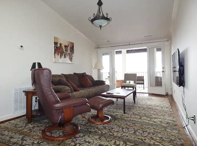 a living room with furniture a large window and a table