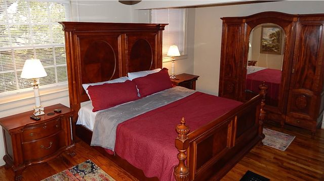 a bed sitting in a bedroom next to a window with dresser