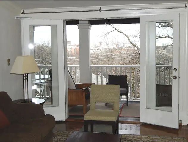 a living room with furniture and a floor to ceiling window
