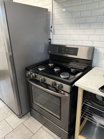 a stove top oven sitting inside of a kitchen