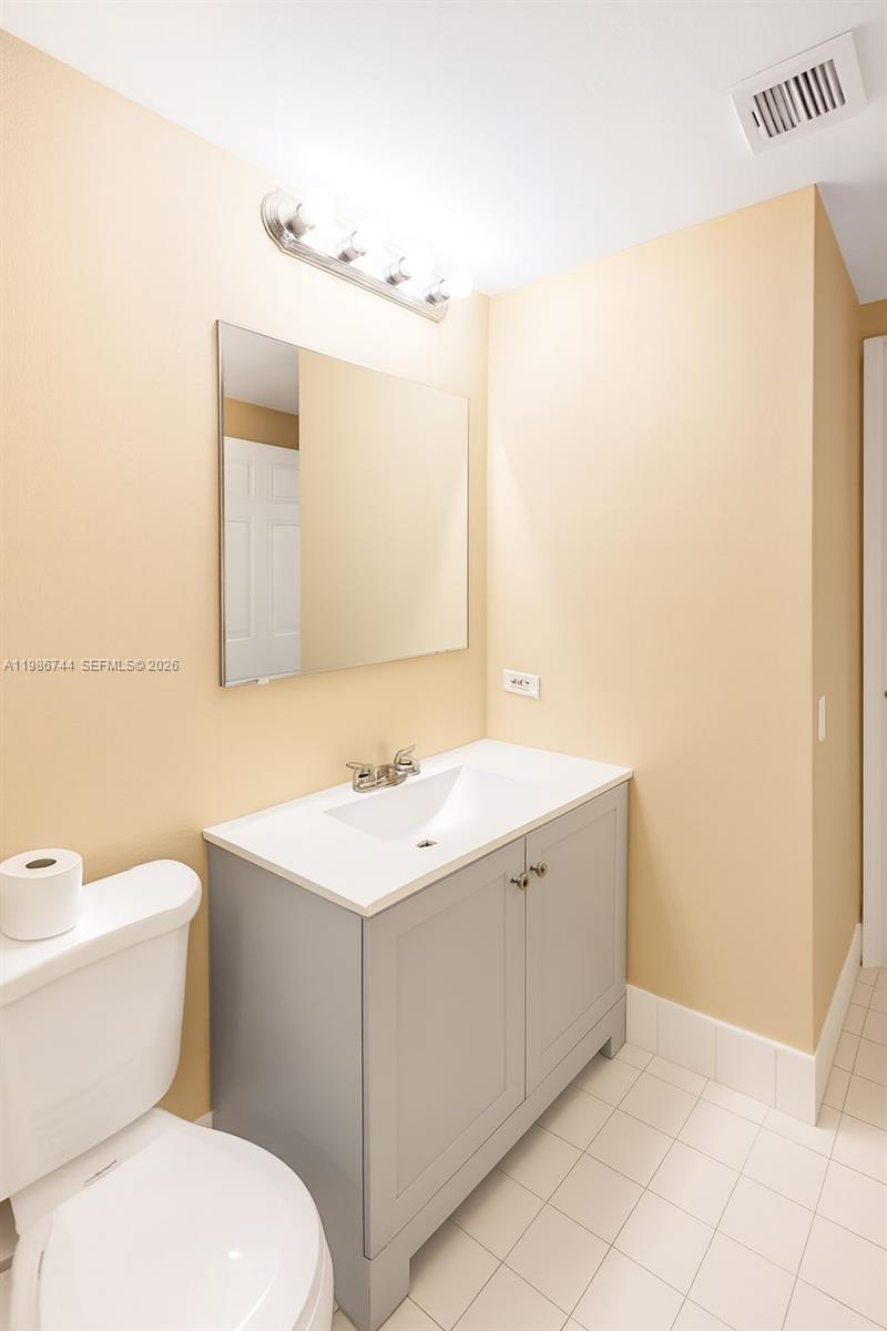 17150 North Bay Road, Unit 2122 Sunny Isles Beach, FL 33160 - Photo 10 of 19 a bathroom with a sink a toilet and mirror