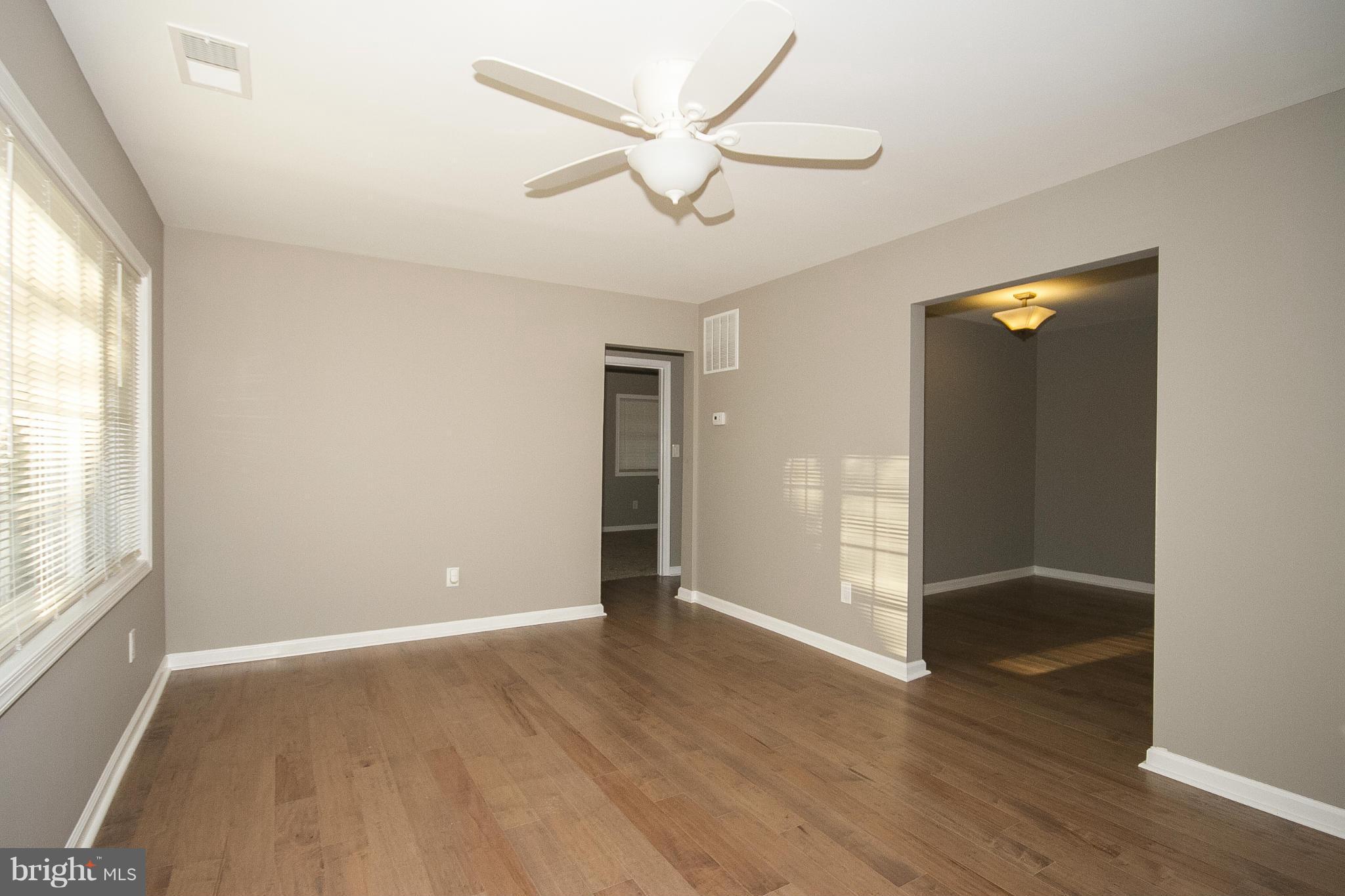 700 Middle River Road Baltimore, MD 21220 - Photo 7 of 29 an empty room with wooden floor and windows
