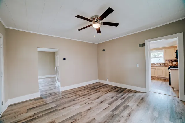 a view of empty room with wooden floor