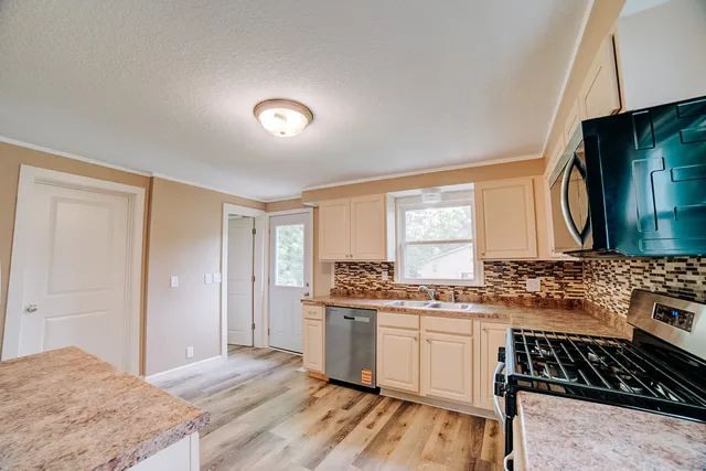 a kitchen with stainless steel appliances a stove sink and cabinets