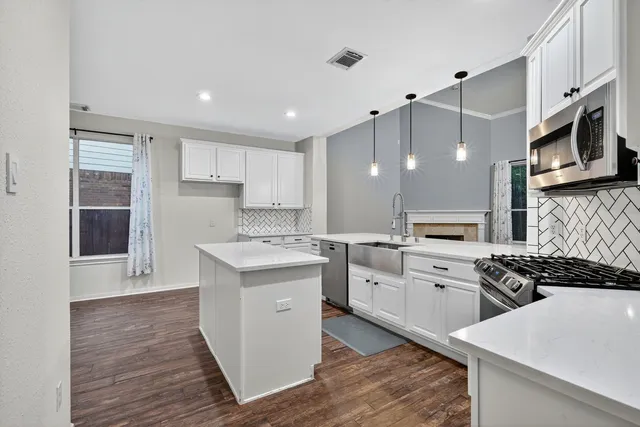 a kitchen with stainless steel appliances a sink stove and refrigerator