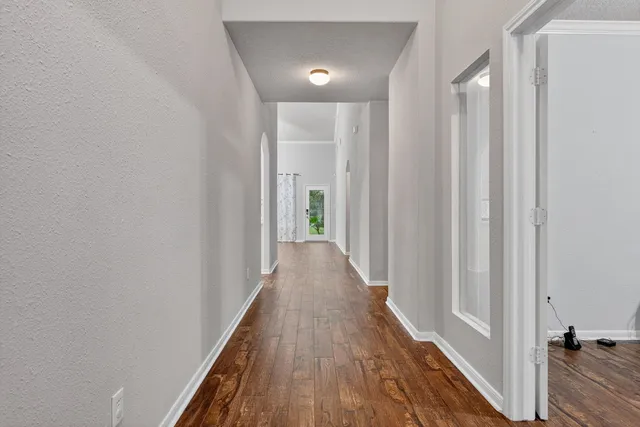 a view of a hallway with wooden floor