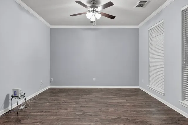 a view of an empty room with window and wooden floor