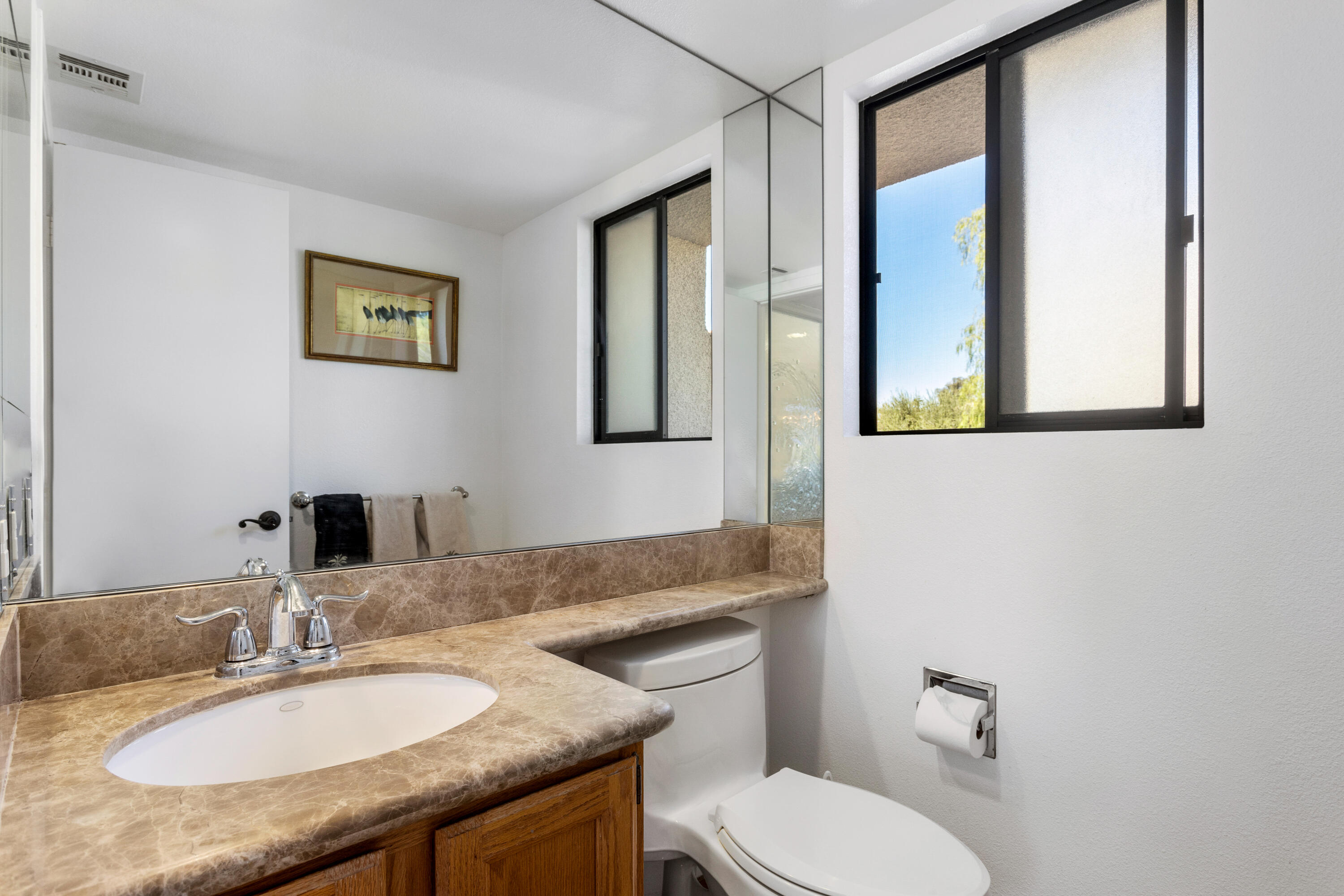 11 Mission Court Rancho Mirage, CA 92270 - Photo 44 of 59 a bathroom with a granite countertop toilet a sink and mirror