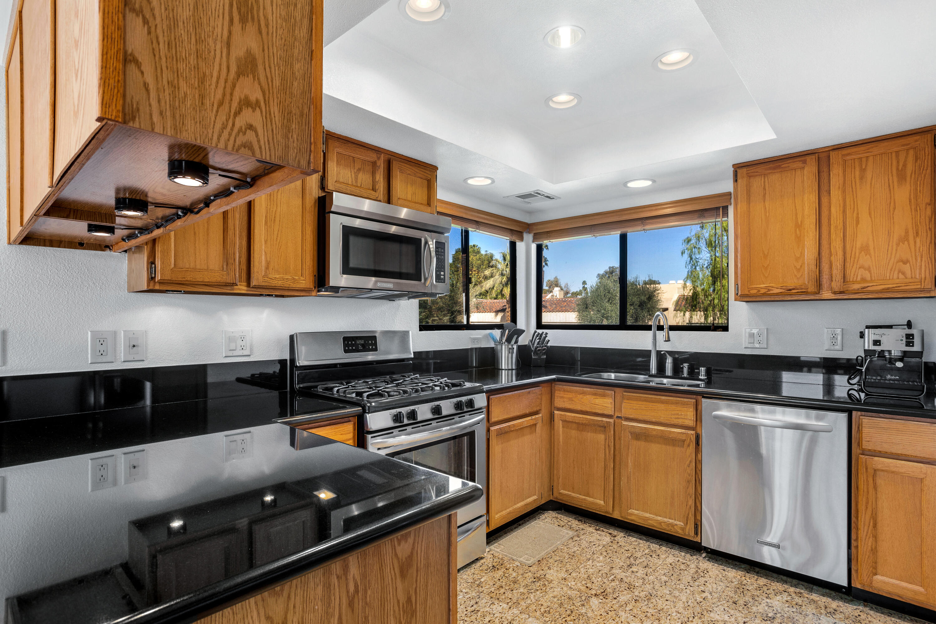 11 Mission Court Rancho Mirage, CA 92270 - Photo 9 of 59 a kitchen with granite countertop a sink a stove top oven and cabinetry