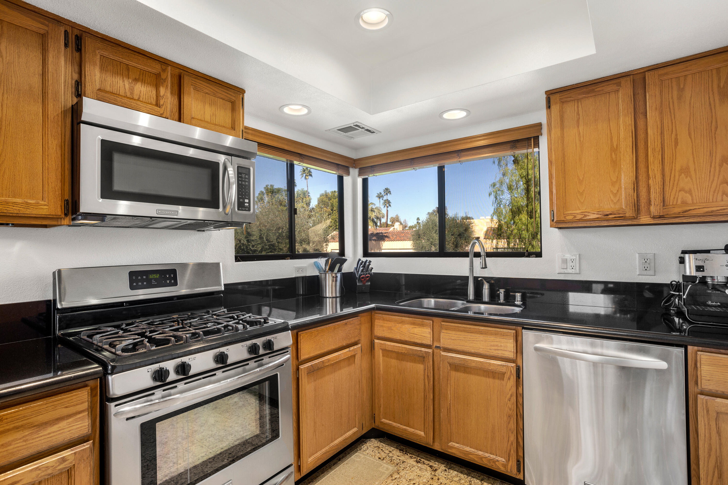 11 Mission Court Rancho Mirage, CA 92270 - Photo 10 of 59 a kitchen with stainless steel appliances granite countertop a stove microwave and sink