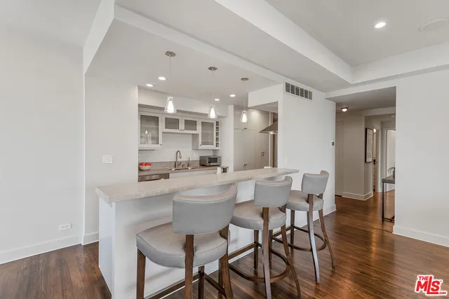 a kitchen with a dining table chairs and wooden floor