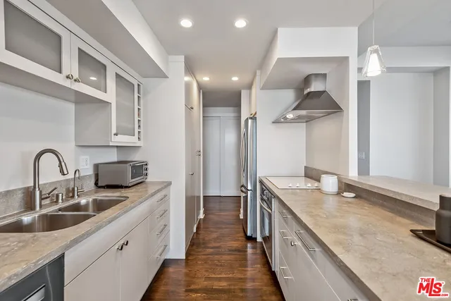 a kitchen with stainless steel appliances granite countertop a sink and a stove top oven