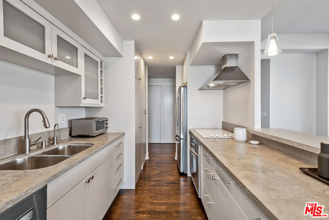 2220 Avenue Of The Stars, Unit 702 Los Angeles, CA 90067 - Photo 6 of 21 a kitchen with stainless steel appliances granite countertop a sink and a stove top oven