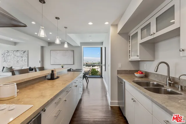 a kitchen with counter top a sink cabinets and appliances