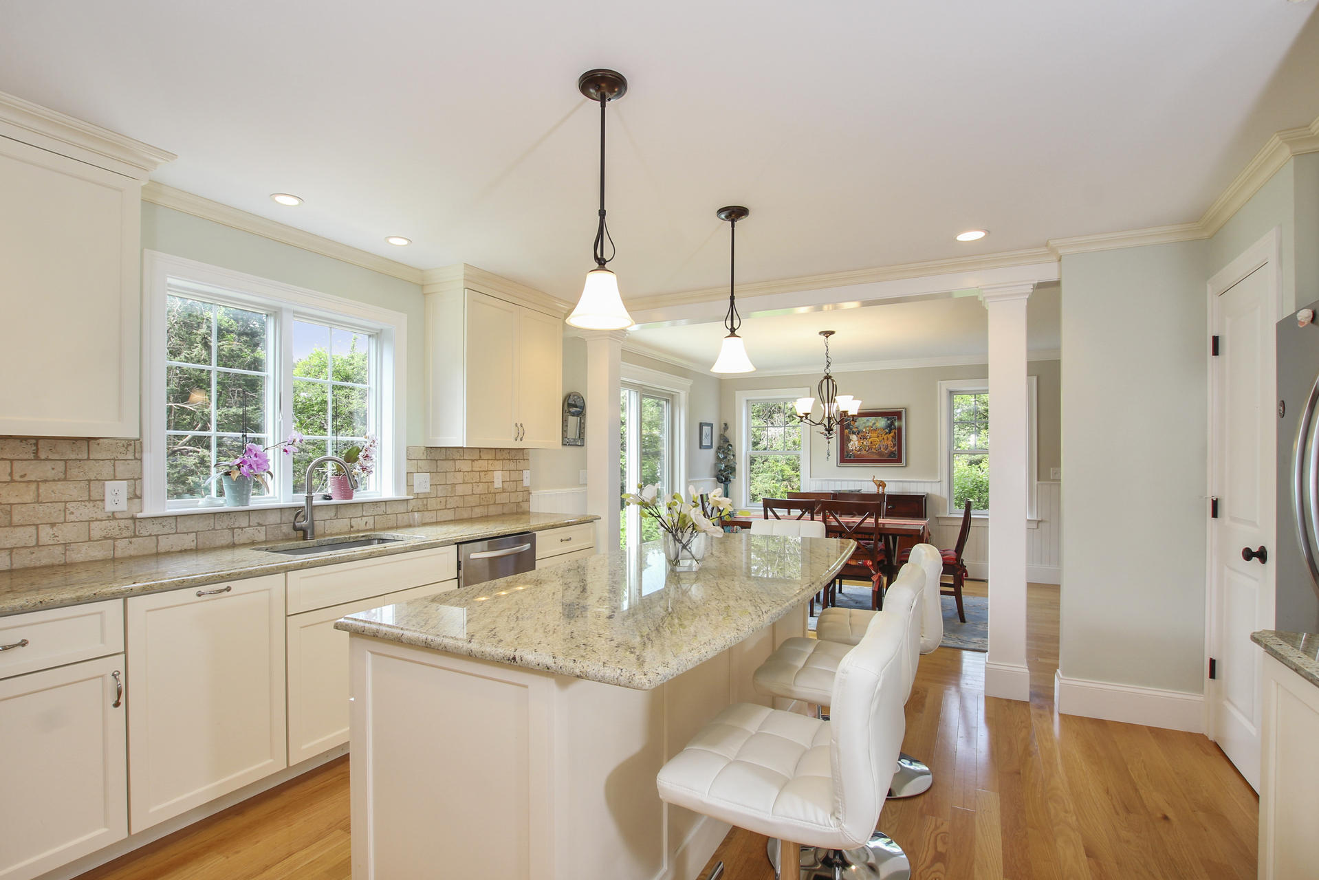 47 Briar Spring Road Orleans, MA 02653 - Photo 11 of 30 a kitchen with stainless steel appliances granite countertop sink stove and white cabinets with wooden floor