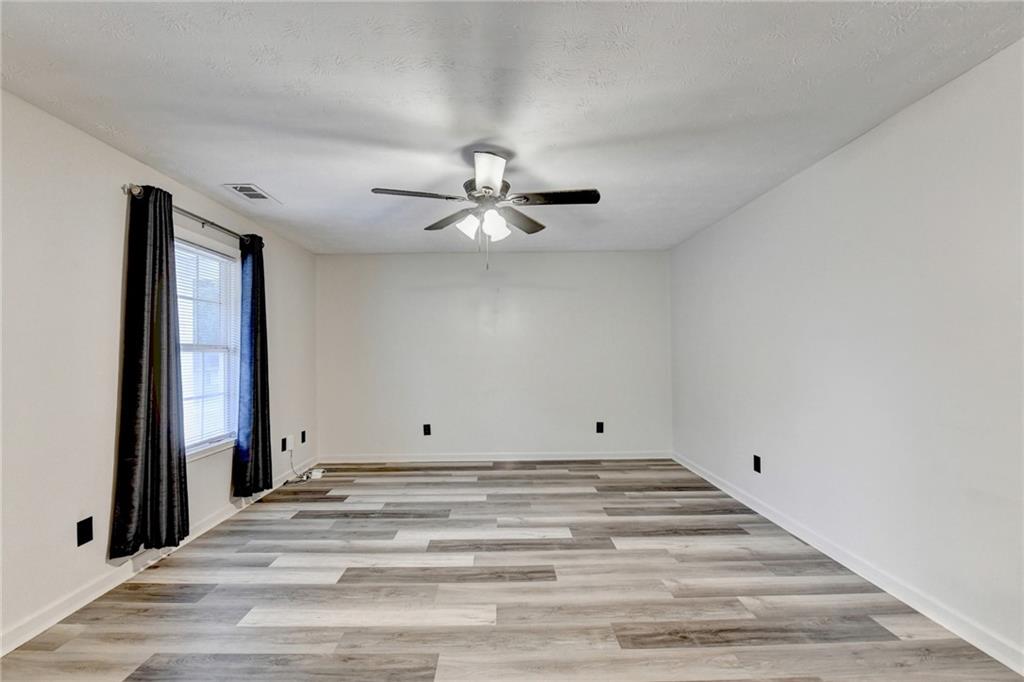 801 Davis Street Monroe, GA 30655 - Photo 5 of 33 wooden floor in an empty room with a window