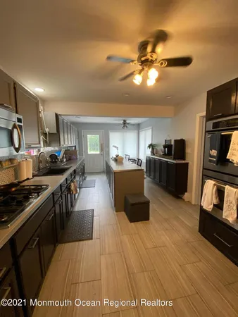 a large kitchen with stainless steel appliances and a view of kitchen