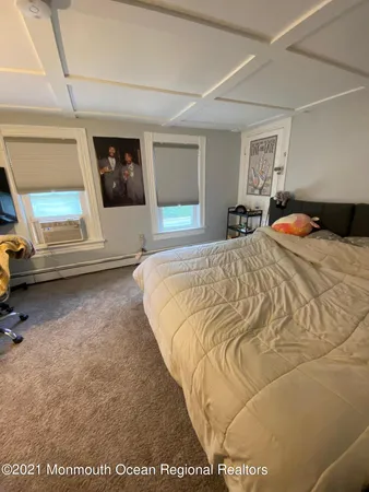 a bed sitting in a spacious bedroom next to a window