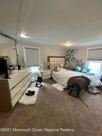 a bedroom with bed a couch and dresser