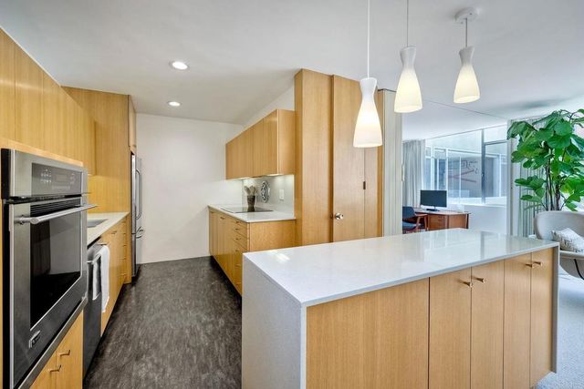 a kitchen with stainless steel appliances a refrigerator and a kitchen island