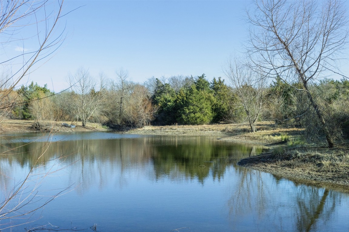 5 County Road 386 Groesbeck, TX 76642 - Photo 11 of 19 a view of a lake with a yard and large trees