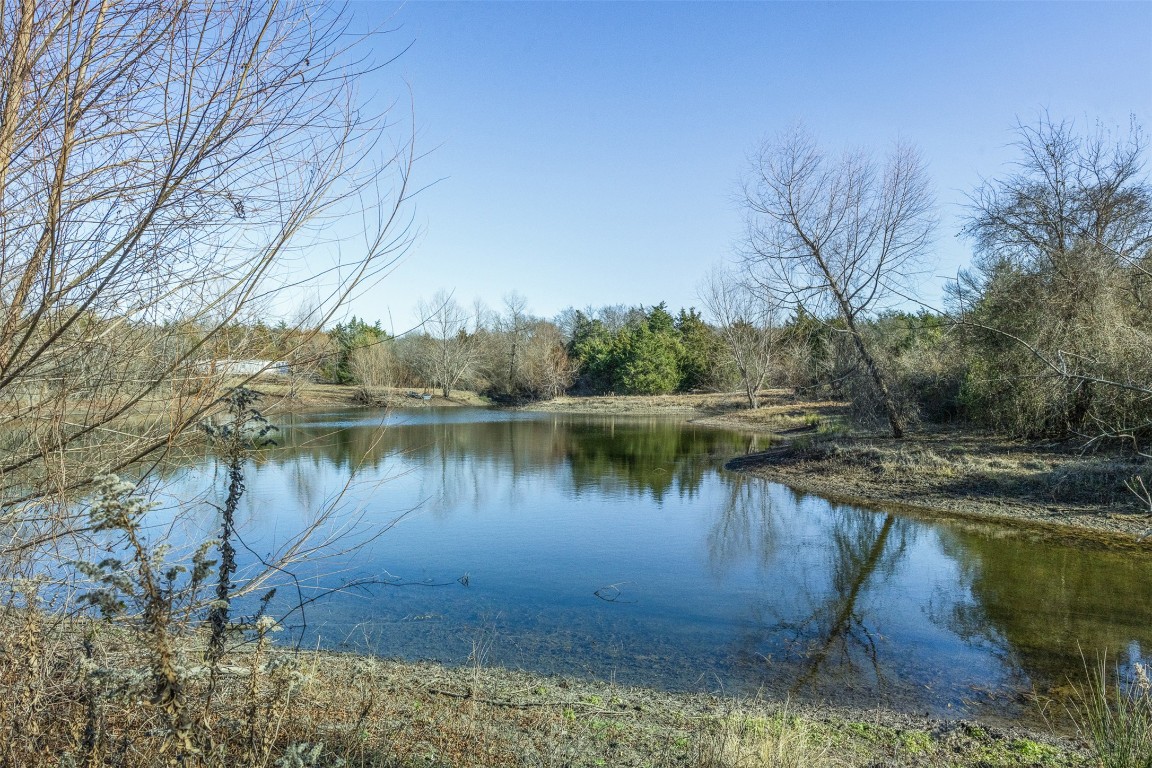 5 County Road 386 Groesbeck, TX 76642 - Photo 10 of 19 a view of a lake with a yard and trees