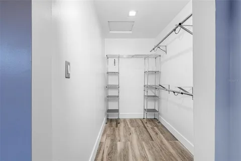 a view of walk in closet with empty racks