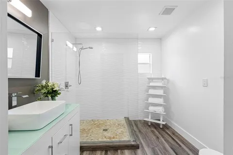 a view of bathroom with a sink potted plants and wooden floor
