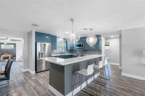 a kitchen with kitchen island a sink stove and refrigerator
