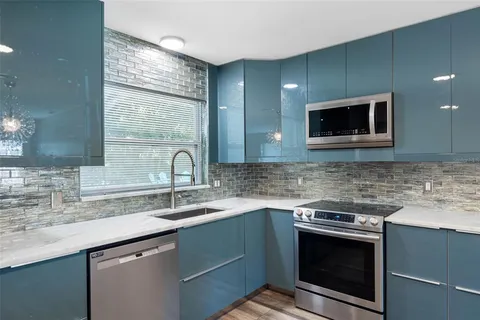 a kitchen with stainless steel appliances granite countertop a sink a stove and microwave