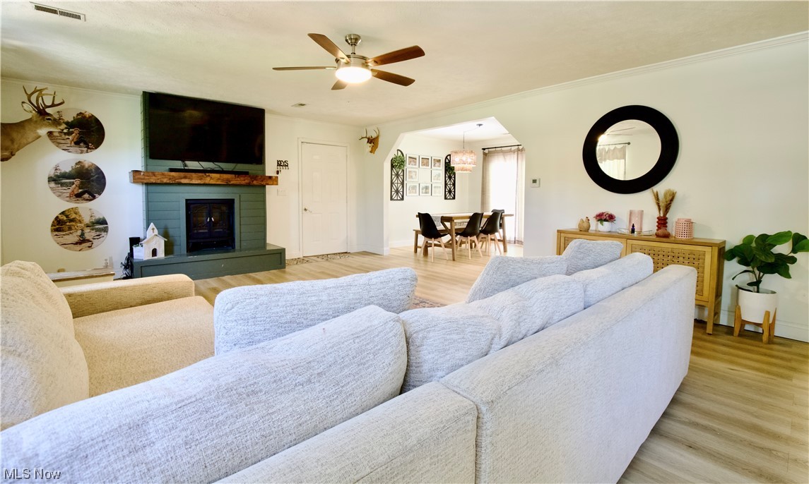 444 Eyermann Road Belpre, OH 45714 - Photo 3 of 16 Living room featuring a brick fireplace, ceiling fan, and light hardwood / wood-style floors