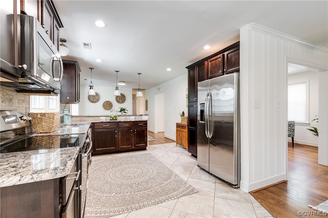 4061 Old Gun Road East Midlothian, VA 23113 - Photo 15 of 42 a kitchen with stainless steel appliances granite countertop a refrigerator a stove and a sink with wooden floor