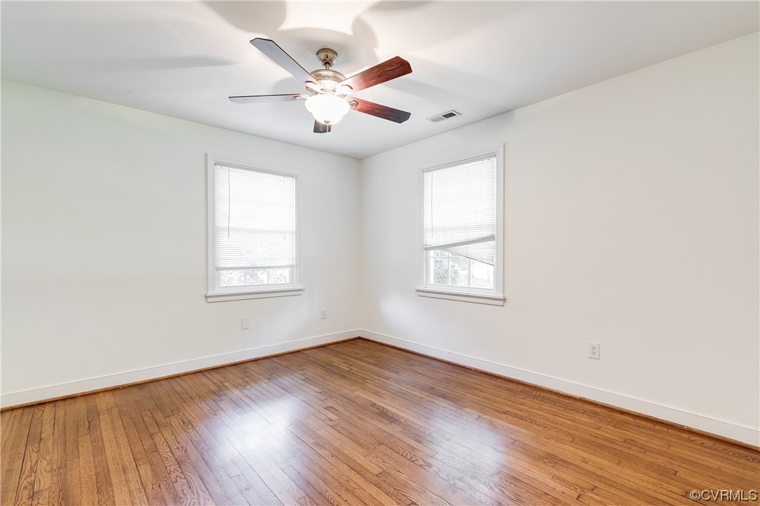 4061 Old Gun Road East Midlothian, VA 23113 - Photo 30 of 42 an empty room with wooden floor chandelier fan and windows