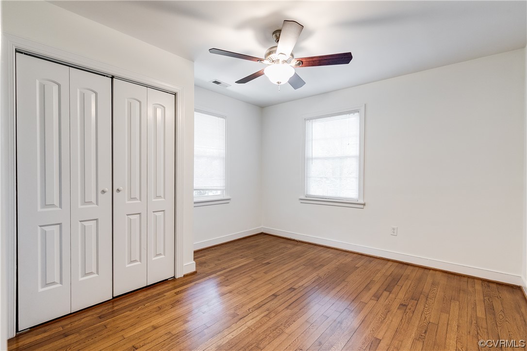 4061 Old Gun Road East Midlothian, VA 23113 - Photo 31 of 42 an empty room with wooden floor chandelier fan and windows