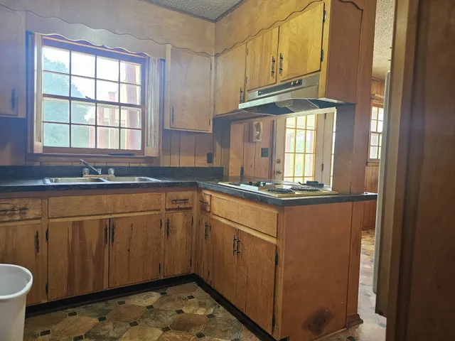 a kitchen with granite countertop cabinets stainless steel appliances and a sink