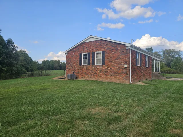 a view of a brick house with a yard