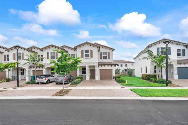 a front view of a building with a garden and plants