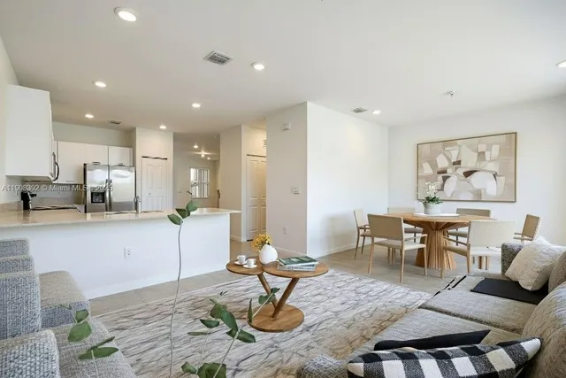 a living room with furniture kitchen view and a table