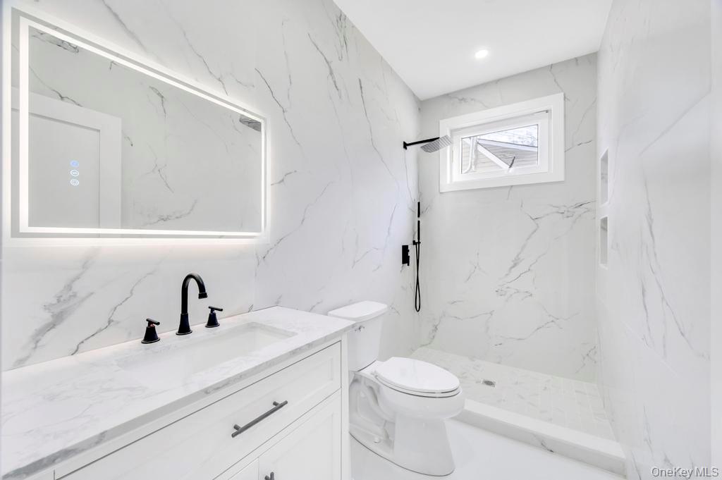 126 Rim Lane Hicksville, NY 11801 - Photo 16 of 28 Bathroom featuring vanity, a marble finish shower, and stone wall