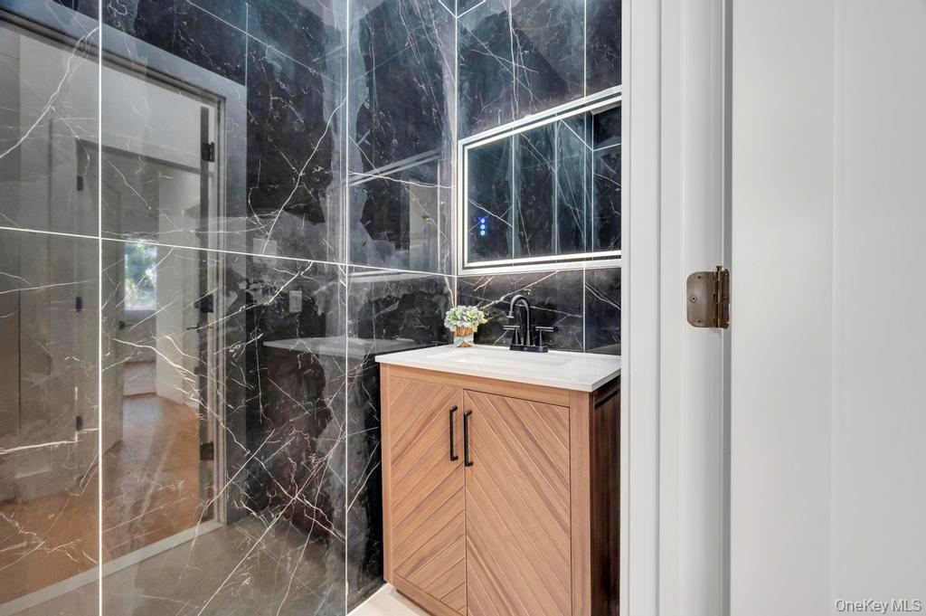 126 Rim Lane Hicksville, NY 11801 - Photo 18 of 28 Bathroom featuring tile walls and vanity