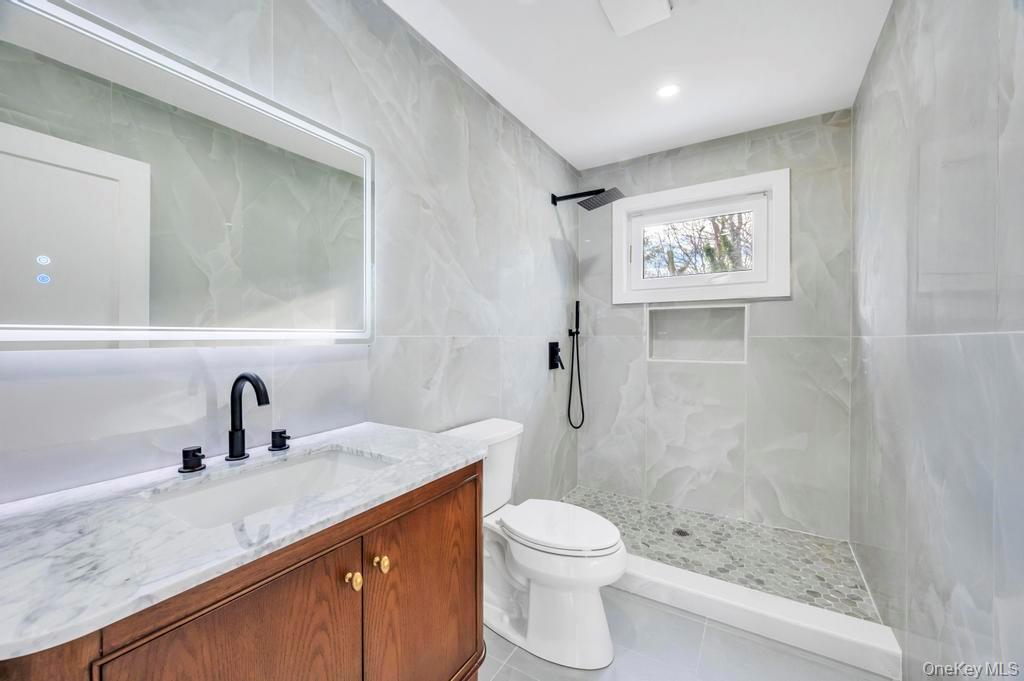 126 Rim Lane Hicksville, NY 11801 - Photo 22 of 28 Bathroom with vanity, tile walls, a marble finish shower, light tile patterned floors, and recessed lighting