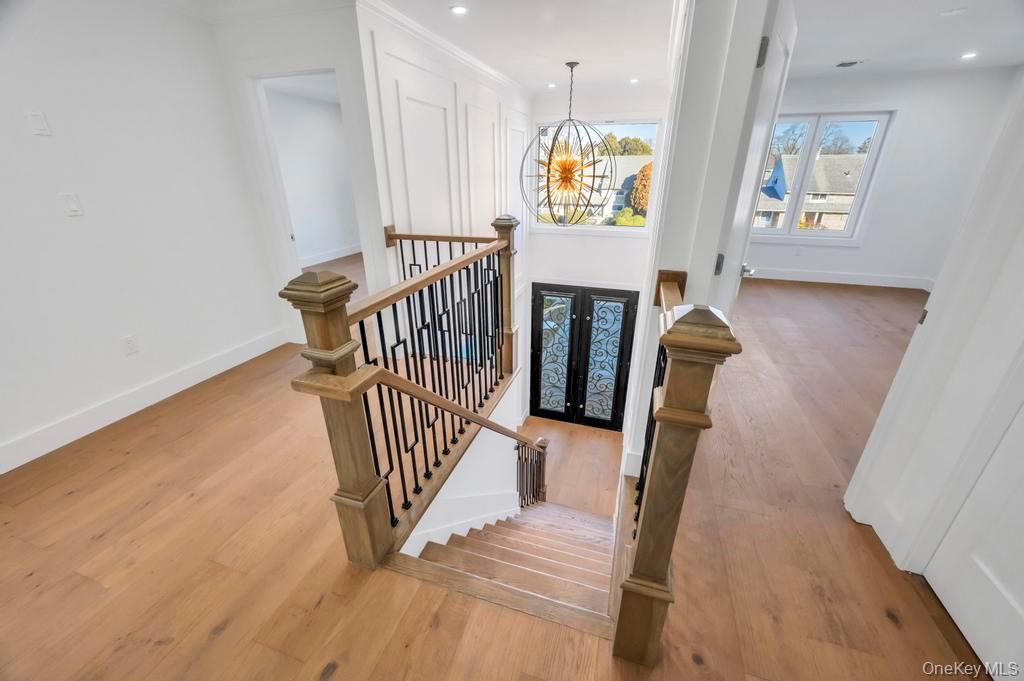 126 Rim Lane Hicksville, NY 11801 - Photo 5 of 28 Stairway featuring a chandelier, wood finished floors, french doors, and recessed lighting