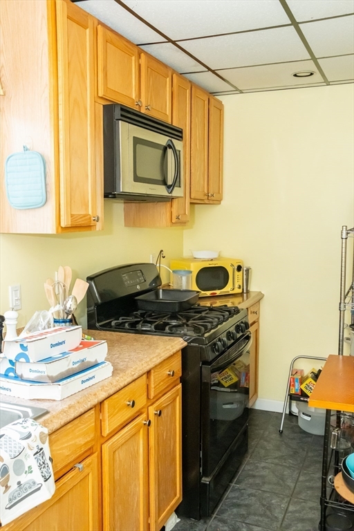 15 Oliver Street Fall River, MA 02724 - Photo 14 of 18 a kitchen with stainless steel appliances granite countertop a stove a sink and a microwave