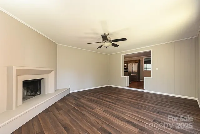 a view of empty room with wooden floor and fireplace