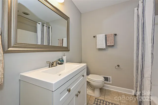a bathroom with a sink toilet and mirror