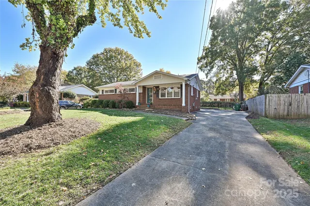 a front view of a house with a garden and trees