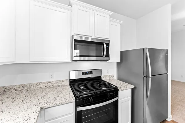 a kitchen with a refrigerator stove and microwave