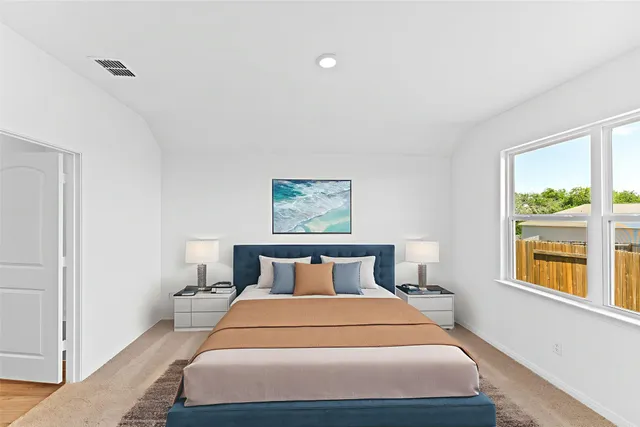 a bedroom with a large bed and a window