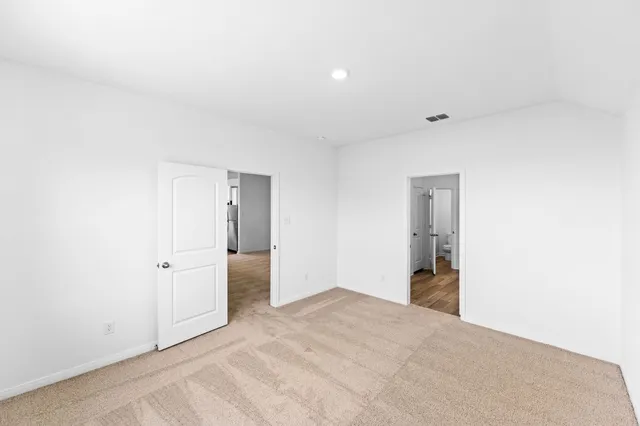 an empty room with closet and windows